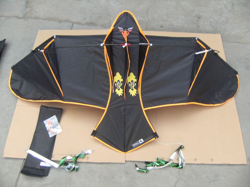 Sort drage med røde kanter og grøn hale